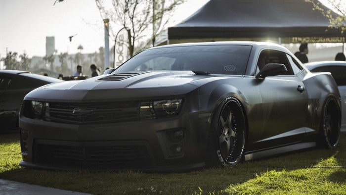 Matte black Chevrolet Camaro parked on grass