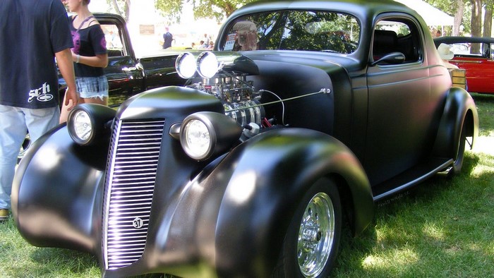 Matte black hot rod car with exposed engine