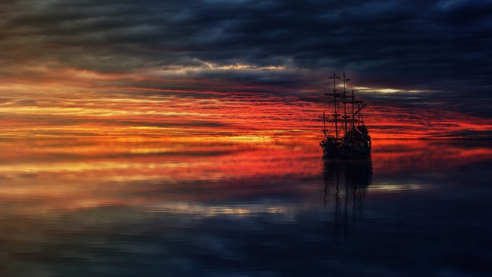 Sailing ship on the ocean at sunset