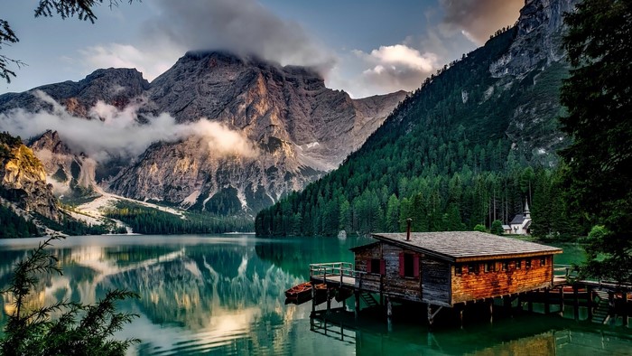 Wooden cabin on a lake in the Dolomites