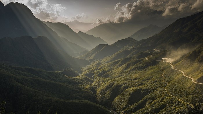 Sunlight beams over a lush green mountain valley in Vietnam