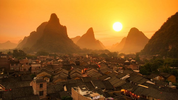 Sunset over Guilin, China with karst mountains and village