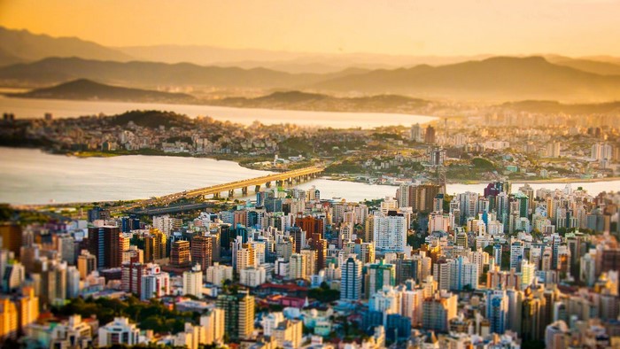 Cityscape with Bridge and Mountains at Sunset