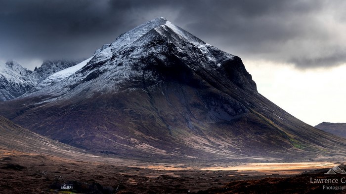 Snow-capped mountain range under stormy skies