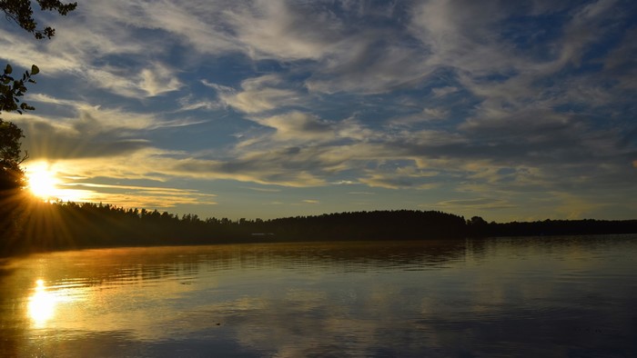 Sunset over a lake with trees and clouds