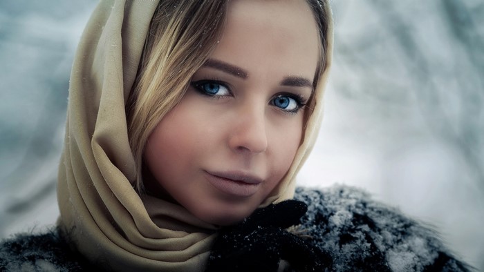 Woman with blue eyes wearing a headscarf in the snow