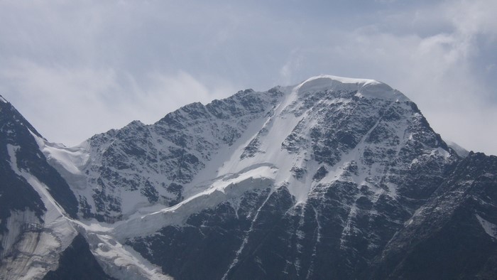 Snow-covered mountain range under a cloudy sky