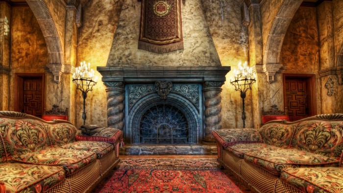 Ornate fireplace in a grand room with antique furniture