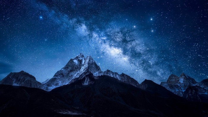 Milky Way over snow-capped mountains at night