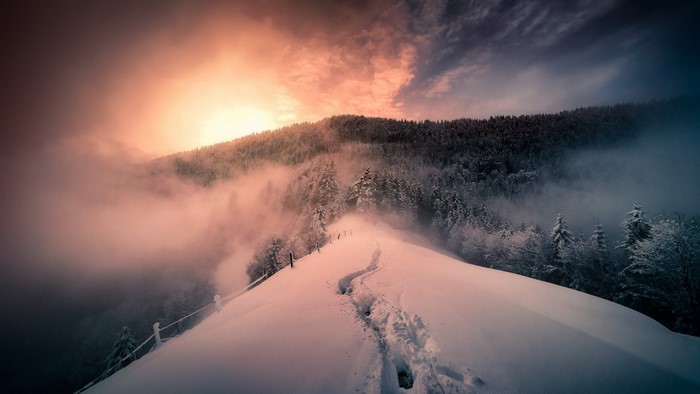 Winter mountain ridge with footprints at sunrise