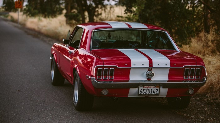 Red Ford Mustang with White Stripes on Road