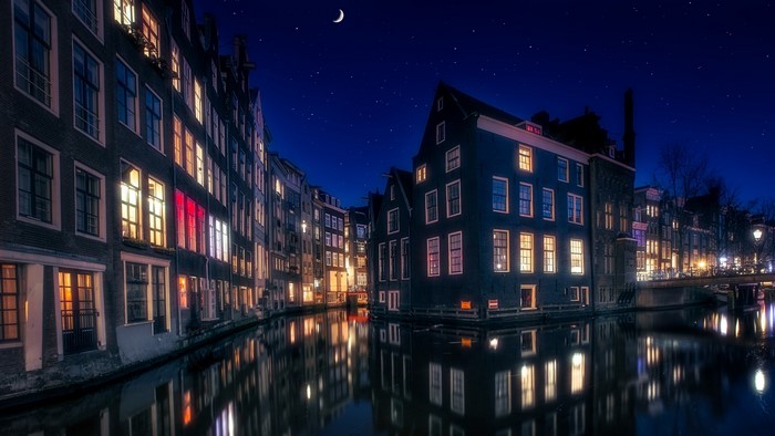 Amsterdam canal at night with crescent moon