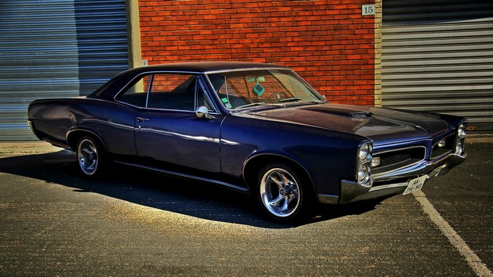 1966 Pontiac GTO parked in front of brick building