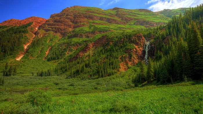 Mountain landscape with waterfall and pine trees