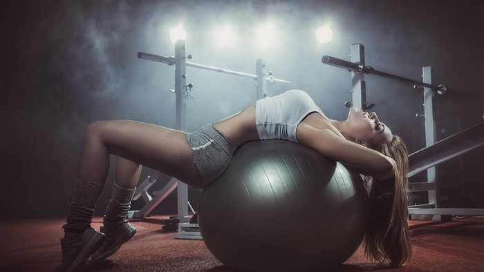 Girl on a fitness ball in a gym