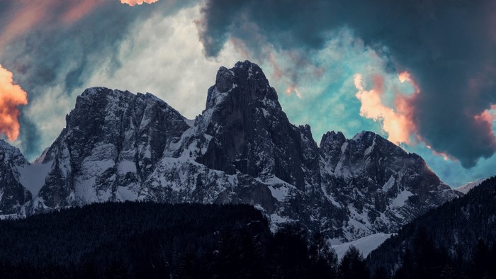 Snowy mountain peaks under dramatic clouds