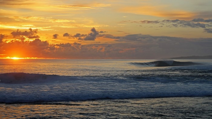 Sunset over the ocean with waves