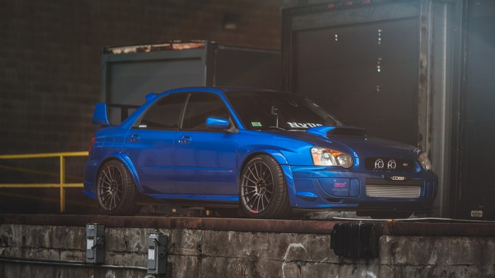 Blue Subaru Impreza STI parked at a loading dock