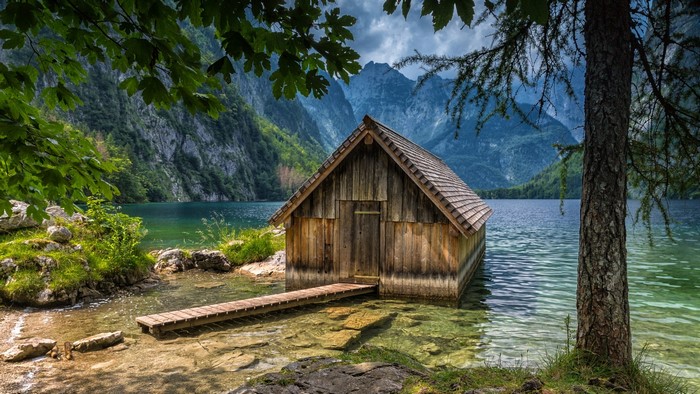 Wooden boathouse on a clear lake in the Bavarian Alps
