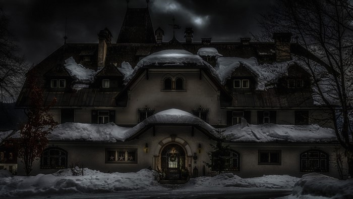 Snow-covered mansion at night