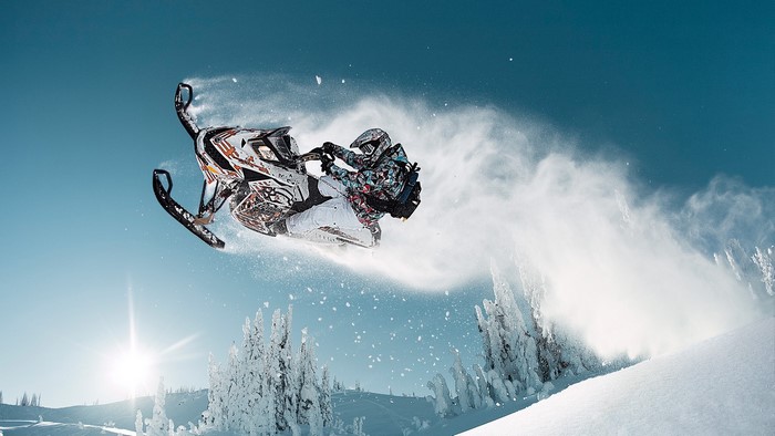 Snowmobiler performing a jump in the air