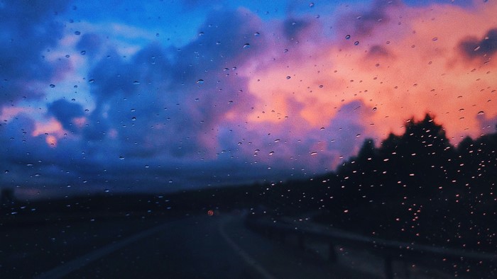 Sunset clouds seen through a rainy window