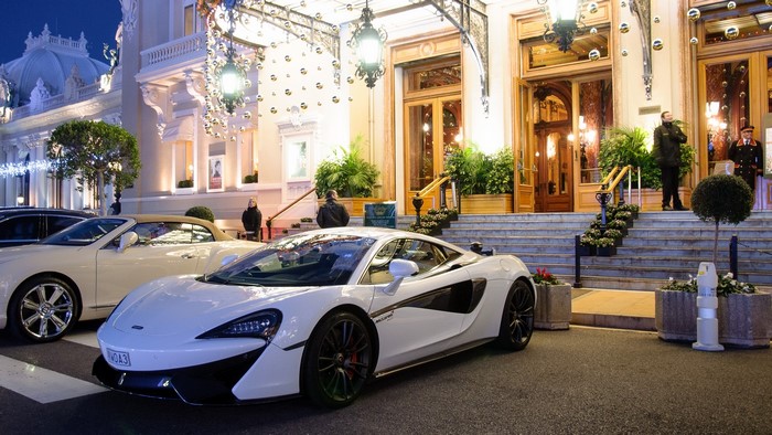White McLaren sports car parked in front of a grand building