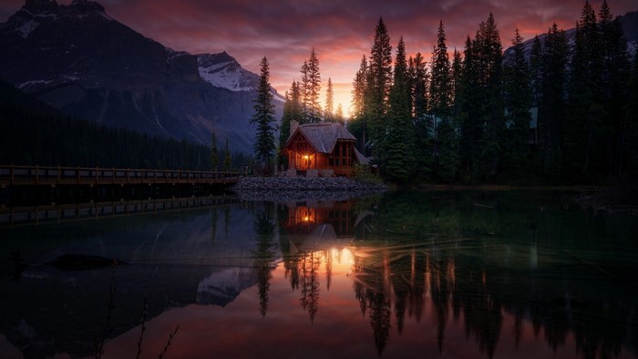 Cabin by a lake at sunset