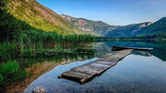Lake with wooden pier and mountains
