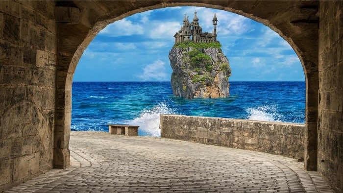 Castle on a rock in the sea viewed through an arch