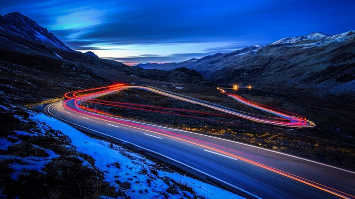 Mountain road with light trails at dusk