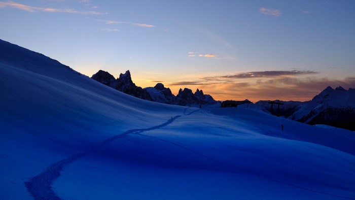 Snowy mountain trail at sunset