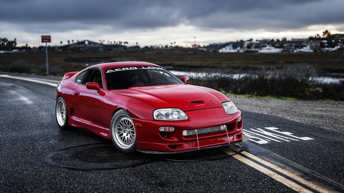 Red Toyota Supra on a wet road