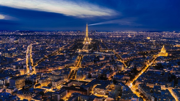 Eiffel Tower illuminated at night over Paris cityscape
