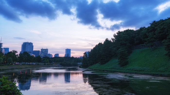 Body of Water and Green Hills with Cityscape