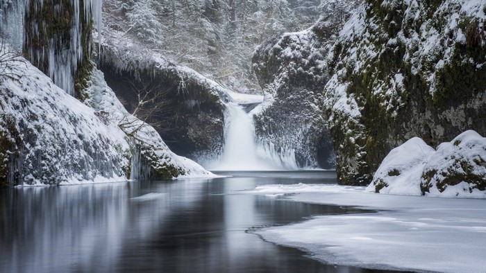Frozen waterfall and river in a snowy forest