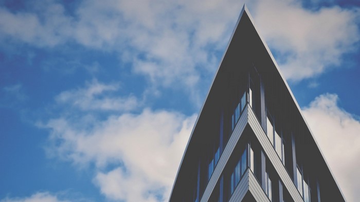 Modern building with sharp angles against a cloudy sky