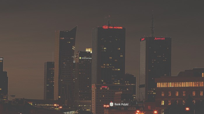 Night cityscape with illuminated skyscrapers and corporate logos