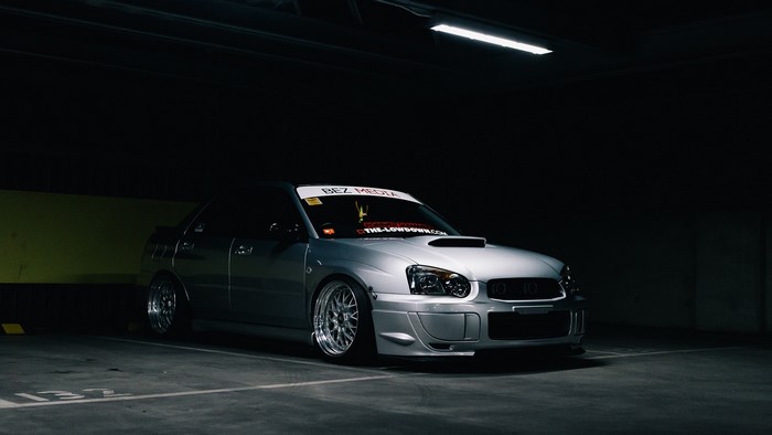 Silver Subaru Impreza in a dimly lit parking garage