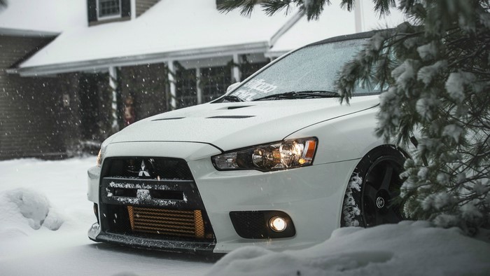 White Mitsubishi Lancer Evolution X in Snow