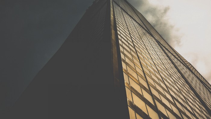 Skyscraper with glass facade against cloudy sky