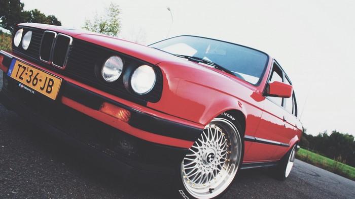 Red BMW E30 with custom wheels