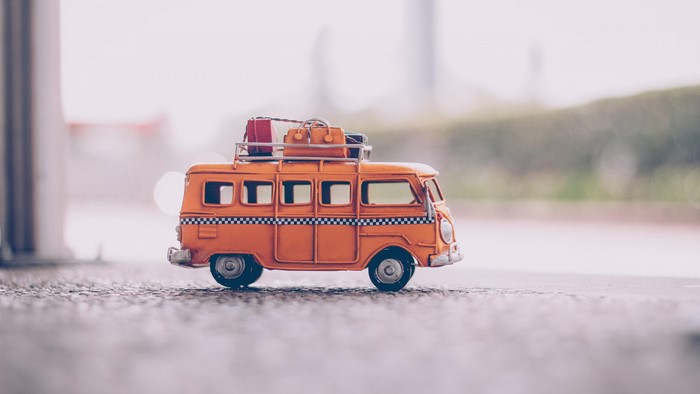 Orange toy van with luggage on roof