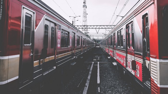 Two red trains on parallel tracks