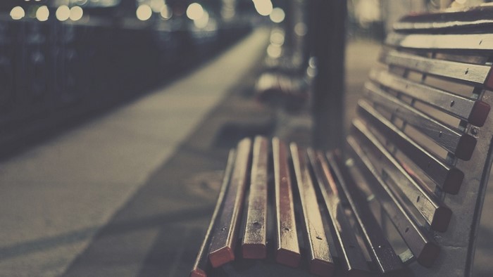 Wooden bench on a sidewalk at night