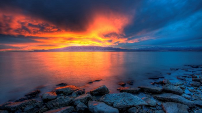 Sunset over a rocky shore and calm water