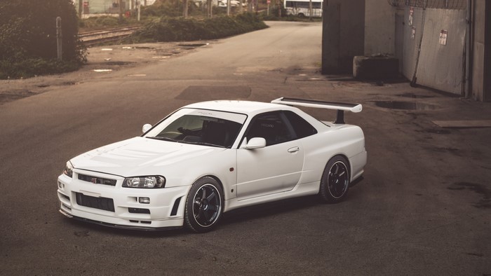 White Nissan Skyline GT-R R34 parked on asphalt