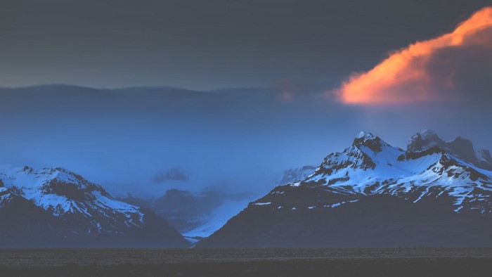 Snowy Mountains in Iceland with Orange Cloud