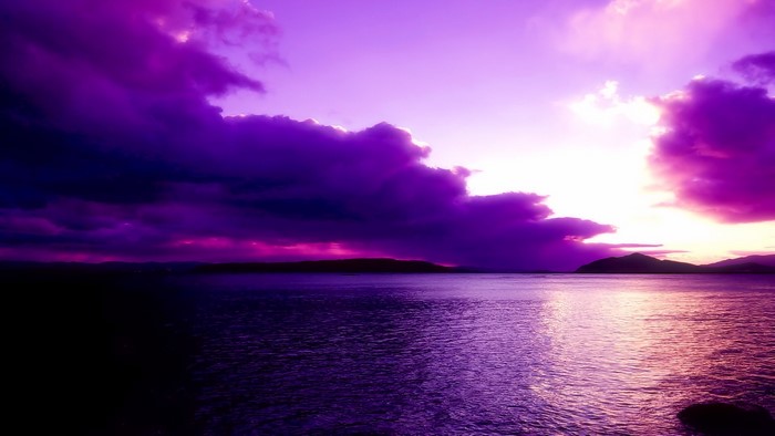 Purple sunset over the ocean with dramatic clouds