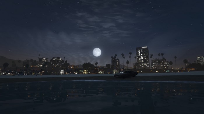 Nighttime cityscape with moon over beach and ocean